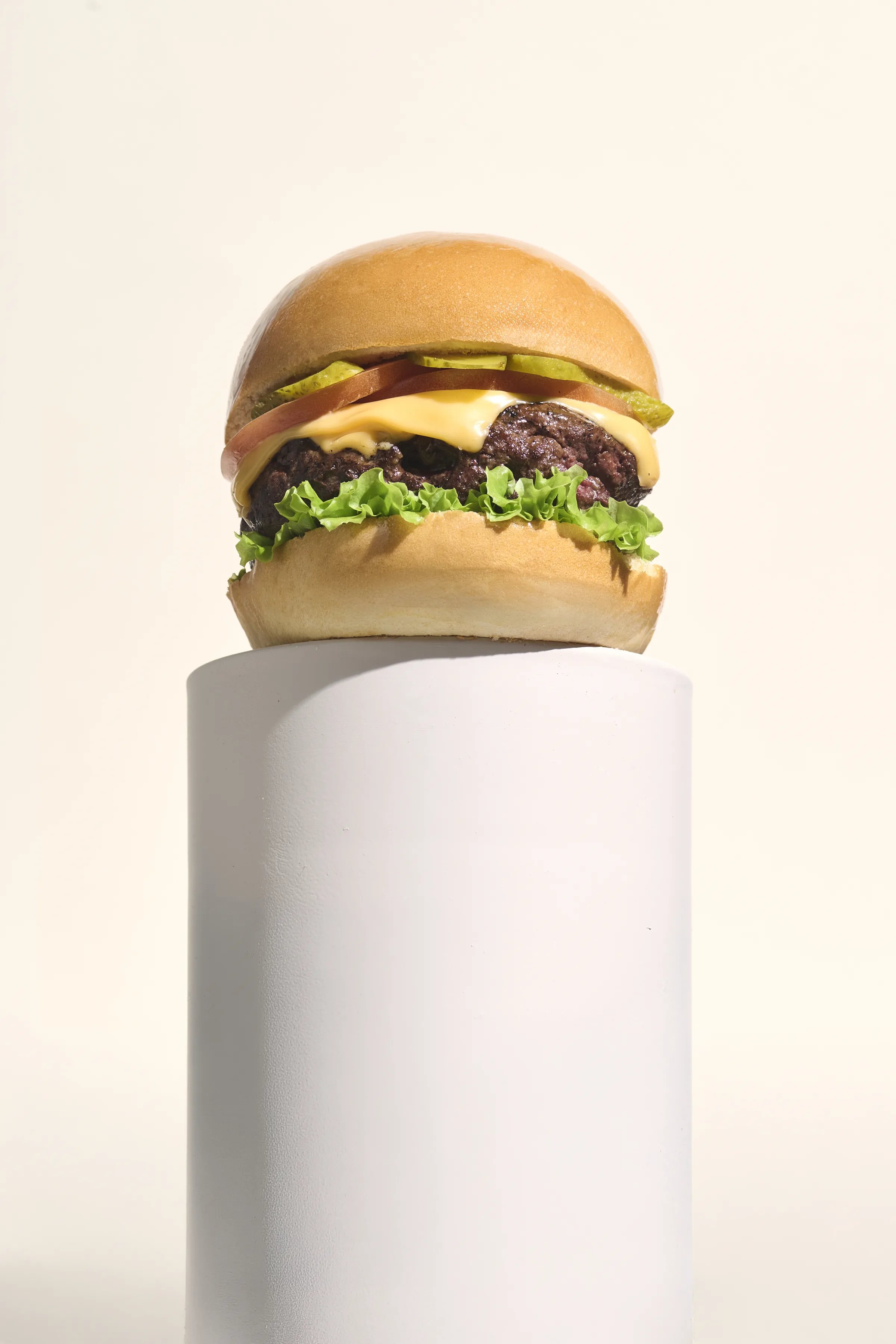 Hamburguesa Lusitana sobre pedestal cilíndrico blanco